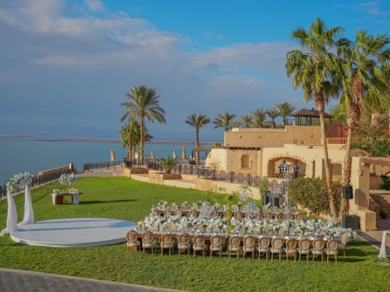 Beautifully arranged venue with flowers and palm trees.