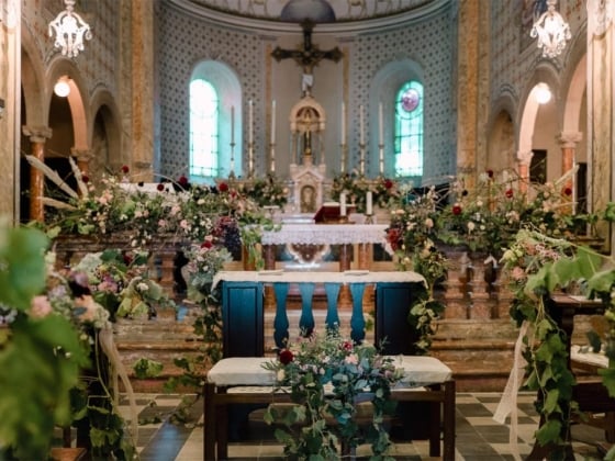A serene church altar adorned with flowers and greenery.