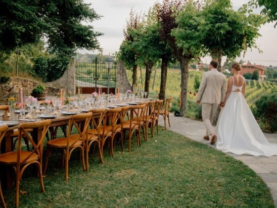 A romantic outdoor dinner setup with a couple in wedding attire.