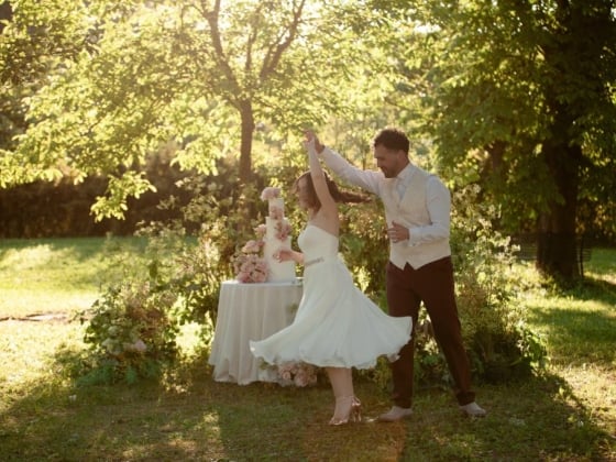 A joyful couple dances amid flowers and sunlight.