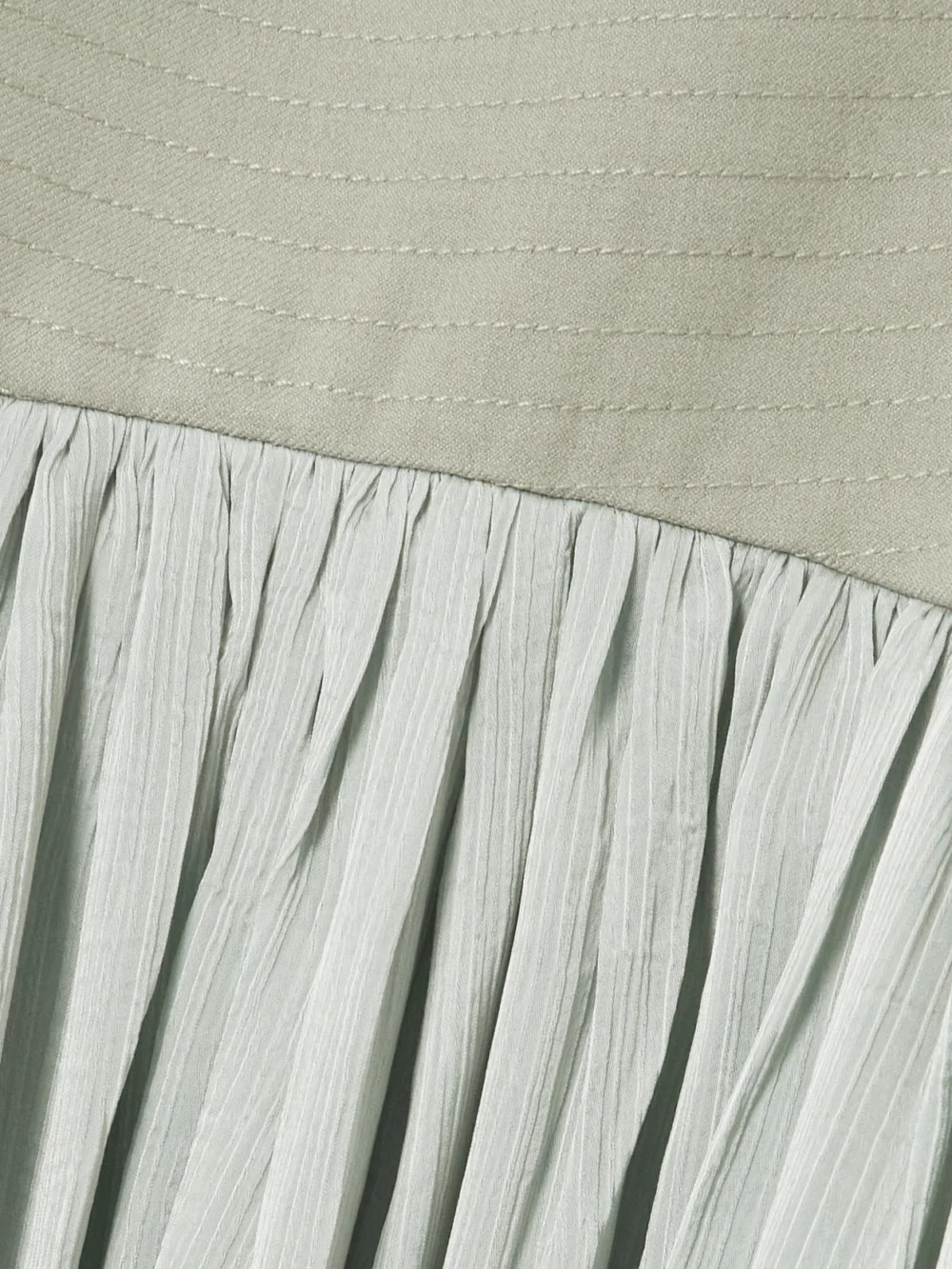 Close-up detail of the Abadia Suri Pleated Twill-trimmed Crepon Gown