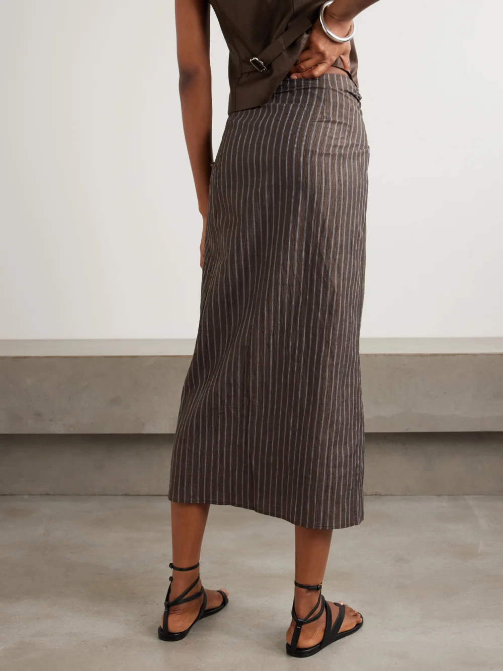 Back view of the Abadia Tie-detailed Pinstriped Linen-blend Midi Skirt