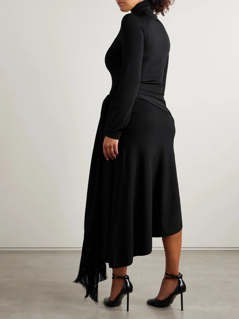 Back view of the Adam Lippes Asymmetric Draped Fringed Stretch-knit Turtleneck Midi Dress