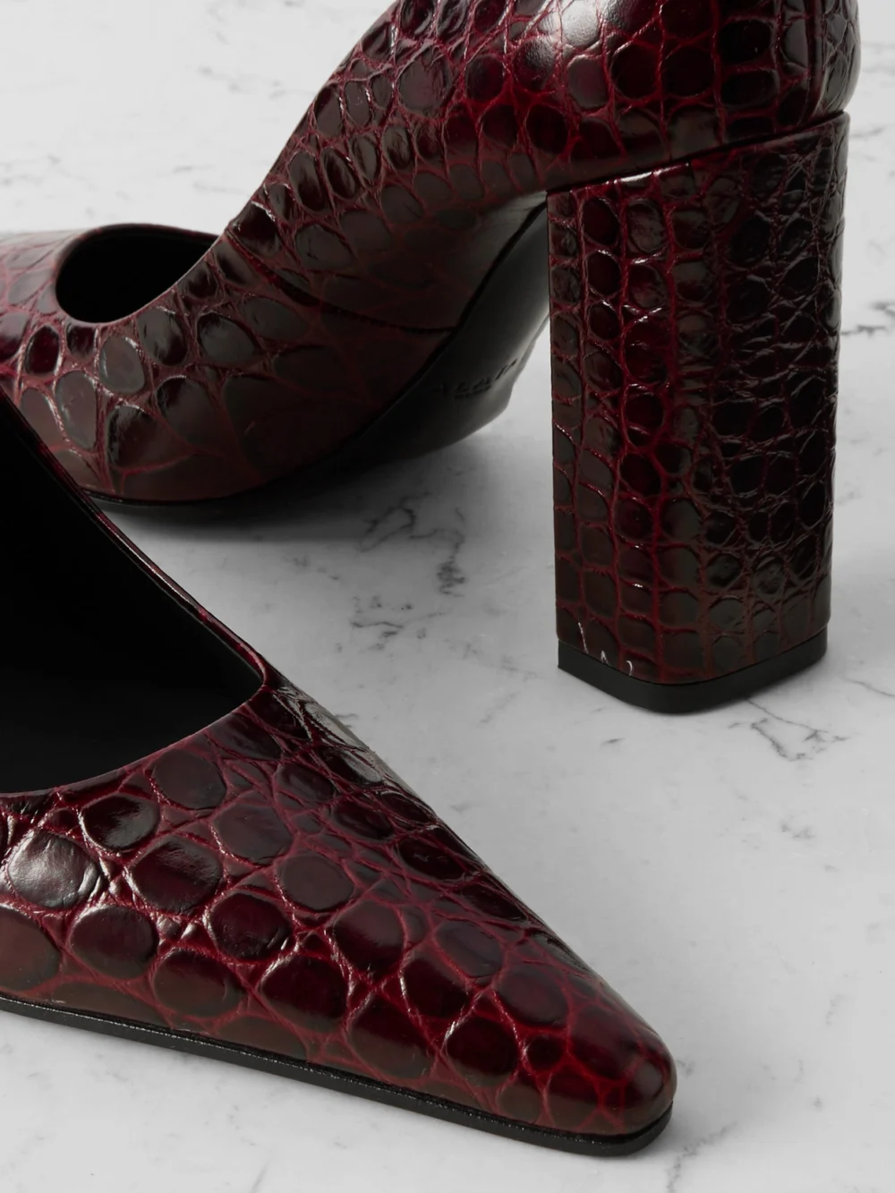 Close-up detail of the Alaïa 90 Croc-effect Leather Pumps