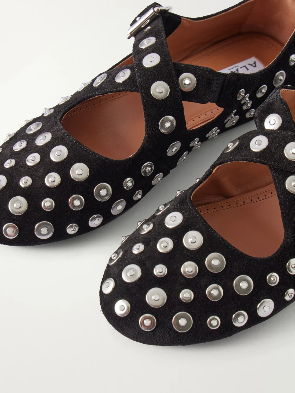 Close-up detail of the Alaïa Criss Cross Embellished Suede Ballet Flats