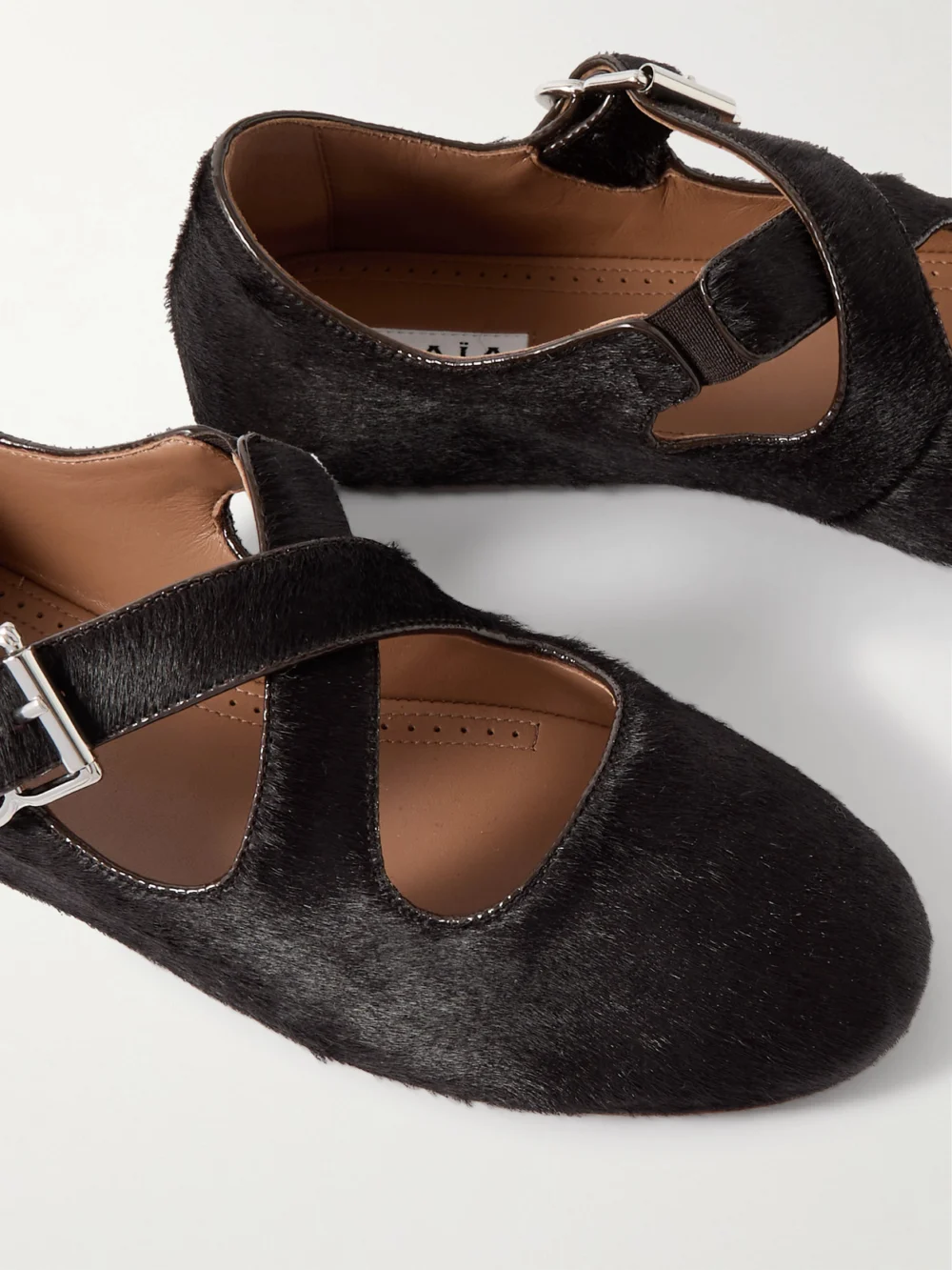 Close-up detail of the Alaïa Criss Cross Leather-trimmed Calf Hair Ballet Flats