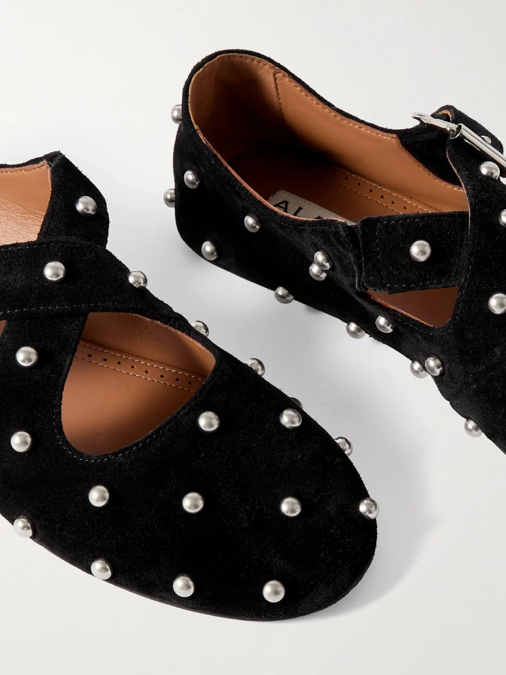 Close-up detail of the Alaïa Criss Cross Studded Suede Ballet Flats