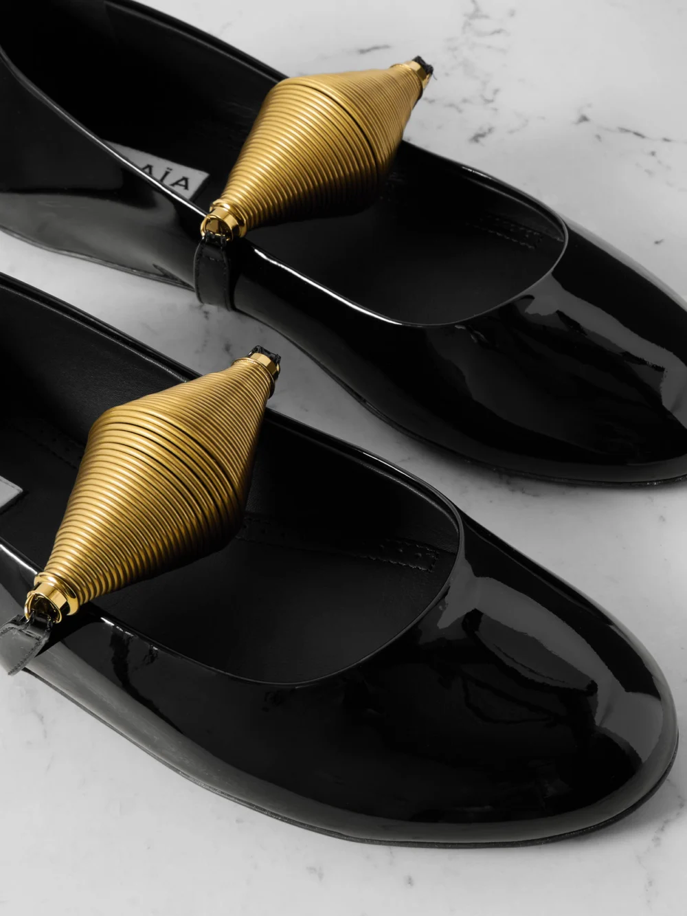 Close-up detail of the Alaïa Embellished Patent-leather Ballet Flats