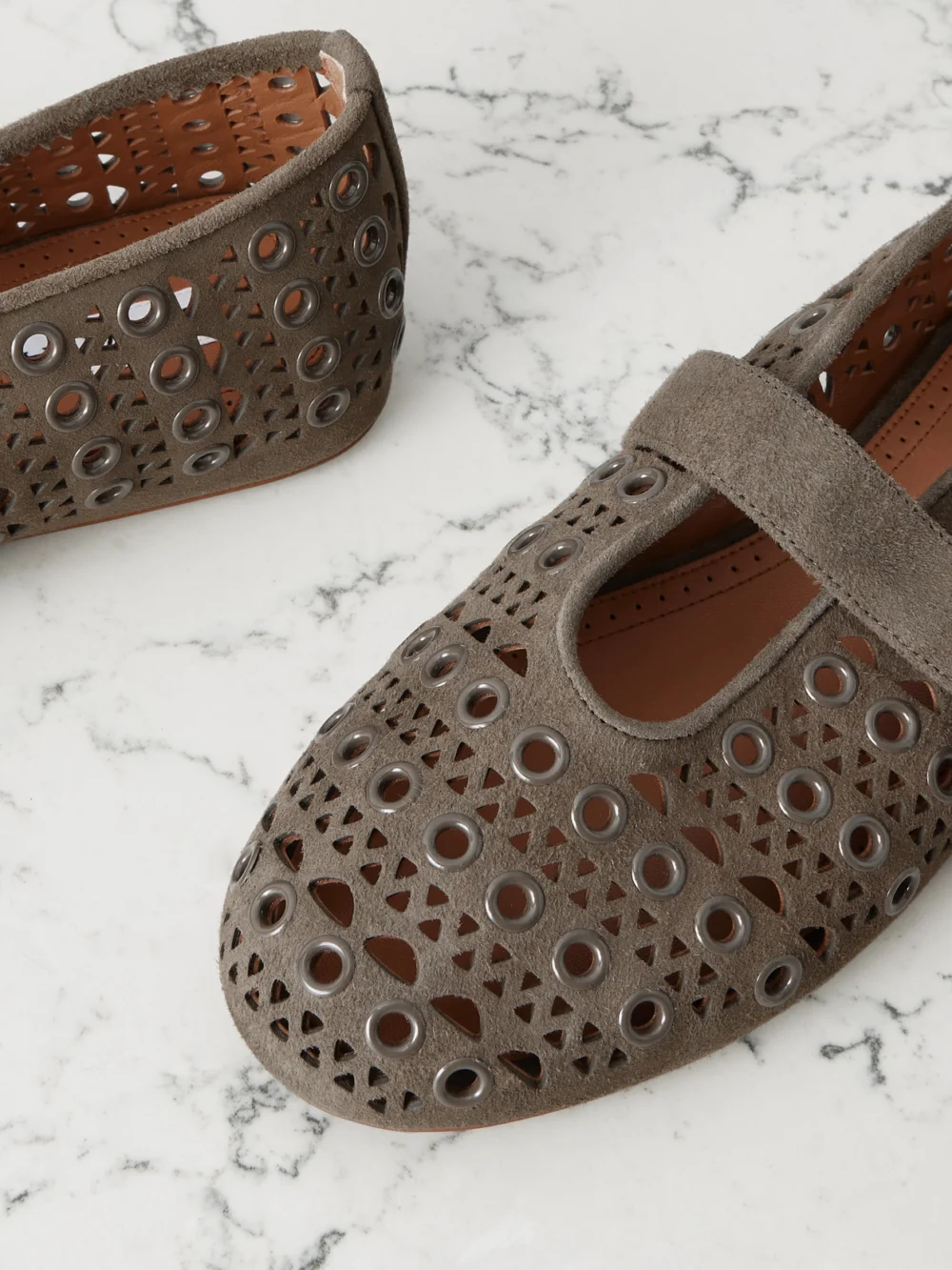 Close-up detail of the Alaïa Eyelet-embellished Perforated Suede Ballet Flats