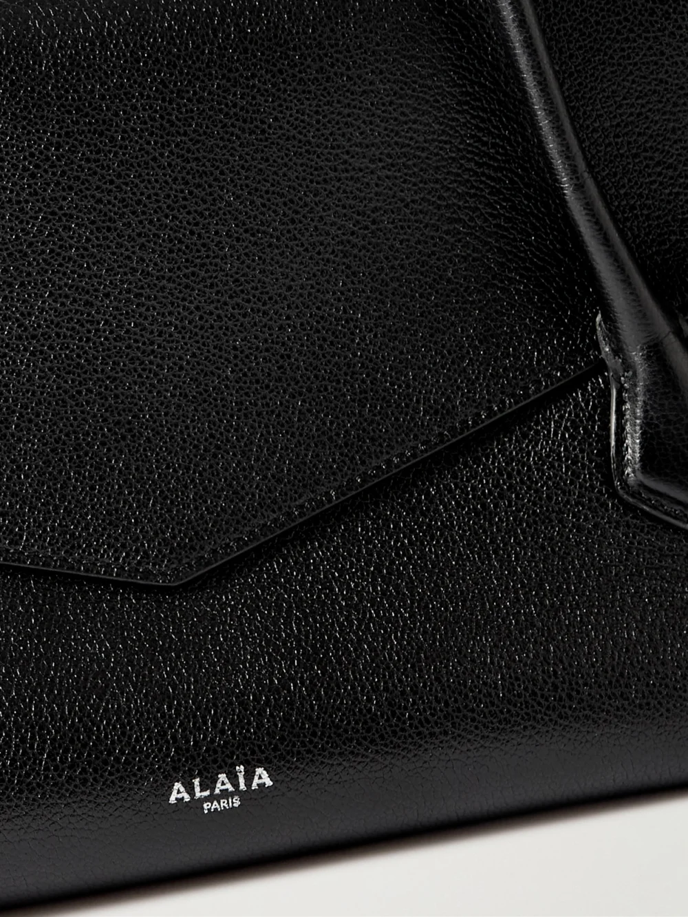 Close-up detail of the Alaïa Le Teckel Flap Textured-leather Shoulder Bag