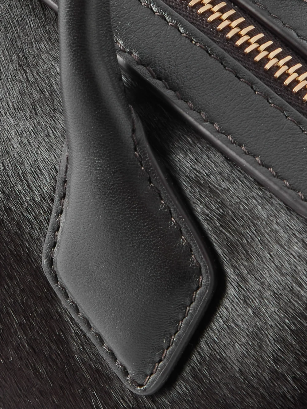 Close-up detail of the Alaïa Le Teckel Leather-trimmed Calf Hair Clutch