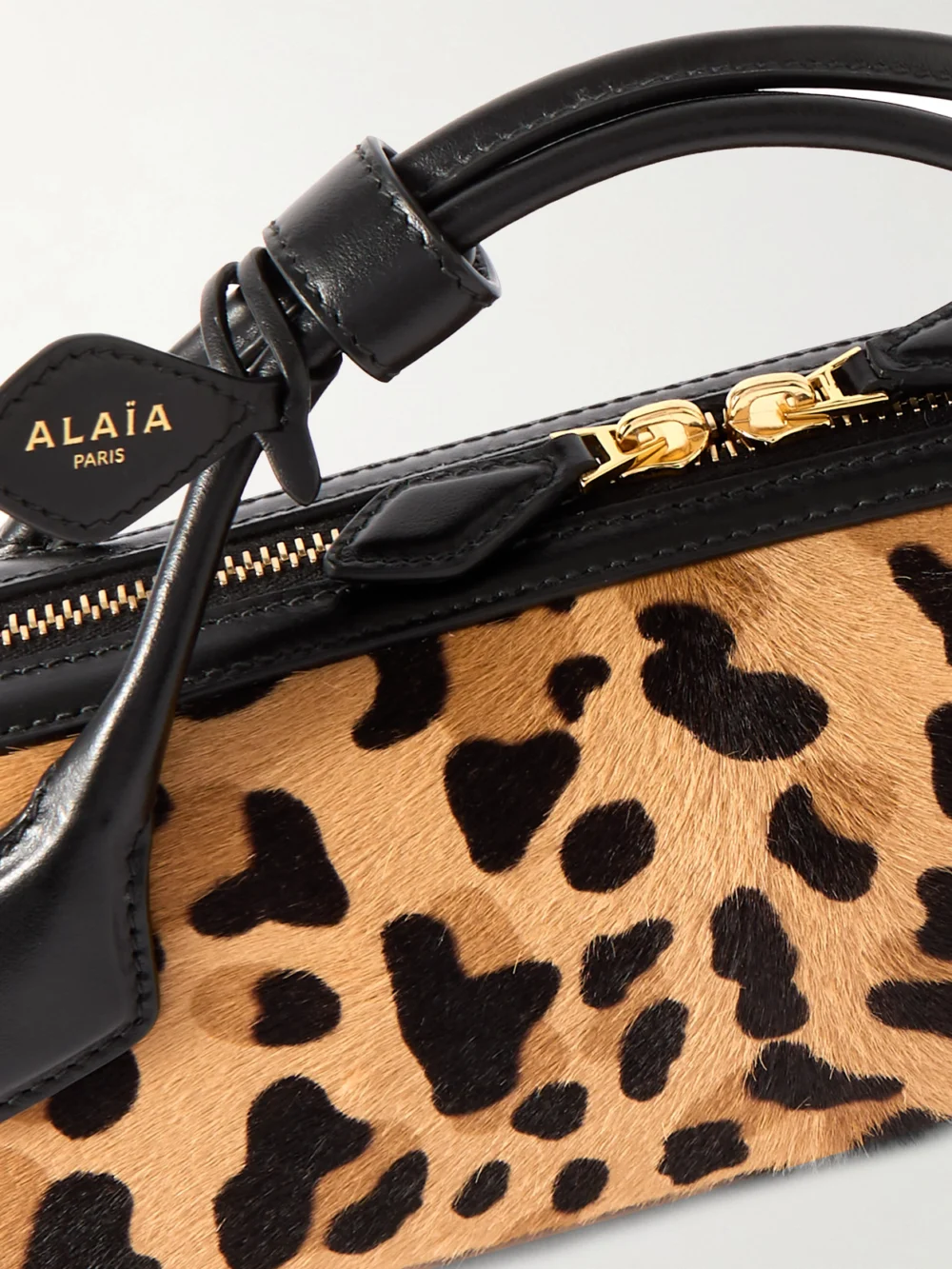 Close-up detail of the Alaïa Le Teckel Leather-trimmed Leopard-print Calf Hair Clutch