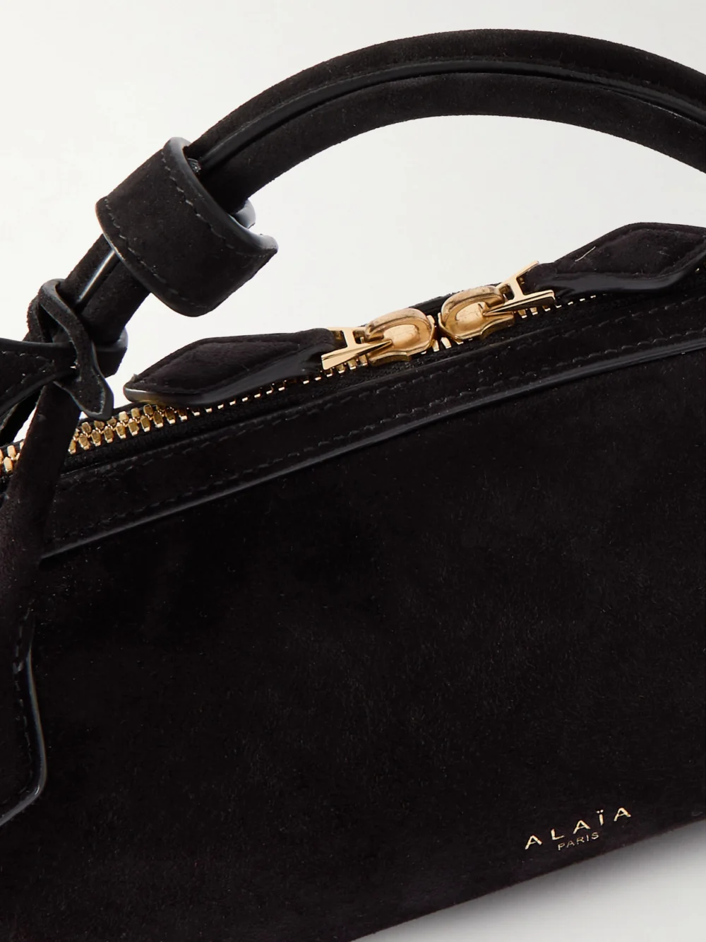 Close-up detail of the Alaïa Le Teckel Leather-trimmed Suede Clutch