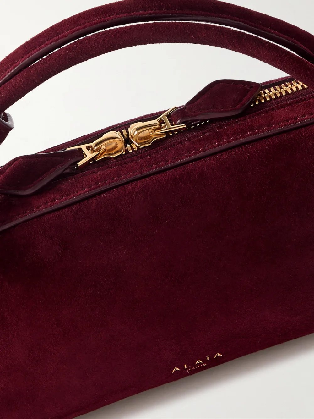 Close-up detail of the Alaïa Le Teckel Leather-trimmed Suede Clutch