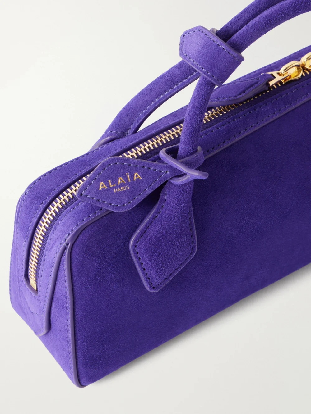 Close-up detail of the Alaïa Le Teckel Leather-trimmed Suede Clutch