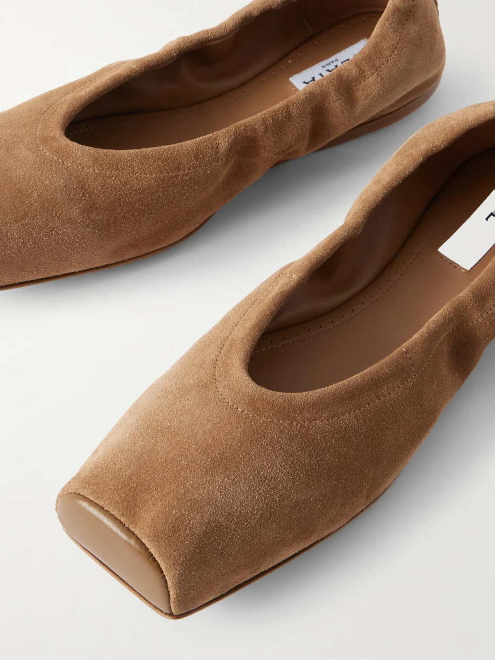 Close-up detail of the Alaïa Leather-trimmed Suede Ballet Flats