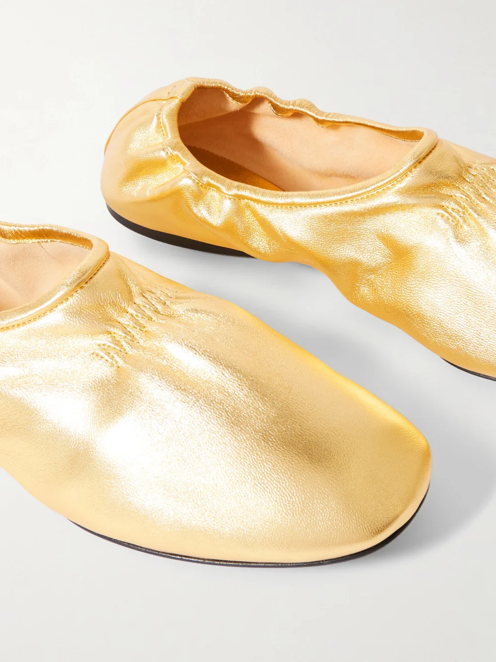 Close-up detail of the Alaïa Metallic Leather Ballet Flats