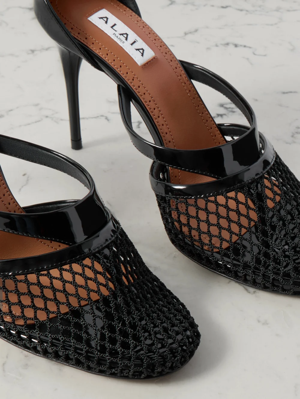 Close-up detail of the Alaïa Patent-leather and Fishnet Pumps
