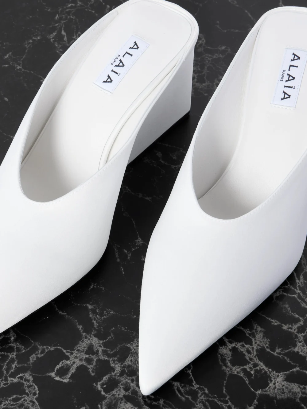 Close-up detail of the Alaïa Satin Point-toe Wedge Mules