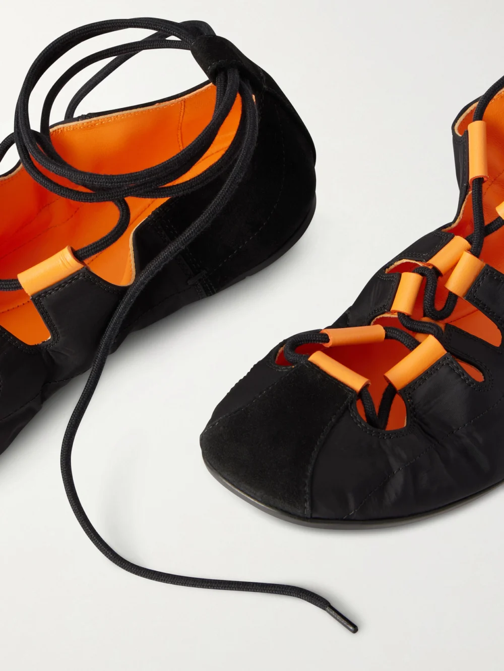 Close-up detail of the Alaïa Suede-trimmed Shell Ballet Flats