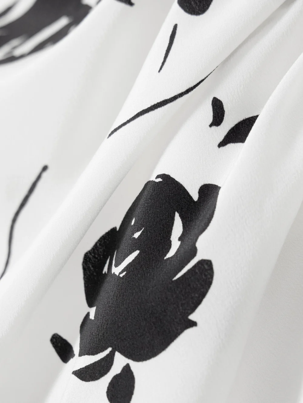 Close-up detail of the Alessandra Rich One-shoulder Bow-detailed Gathered Floral-print Silk Mini Dress