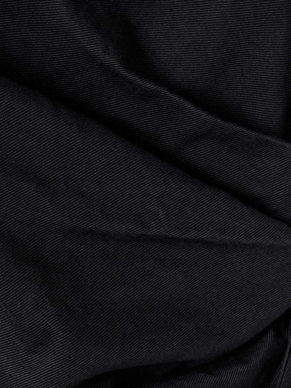 Close-up detail of the Alexander McQueen Gathered Denim Mini Dress