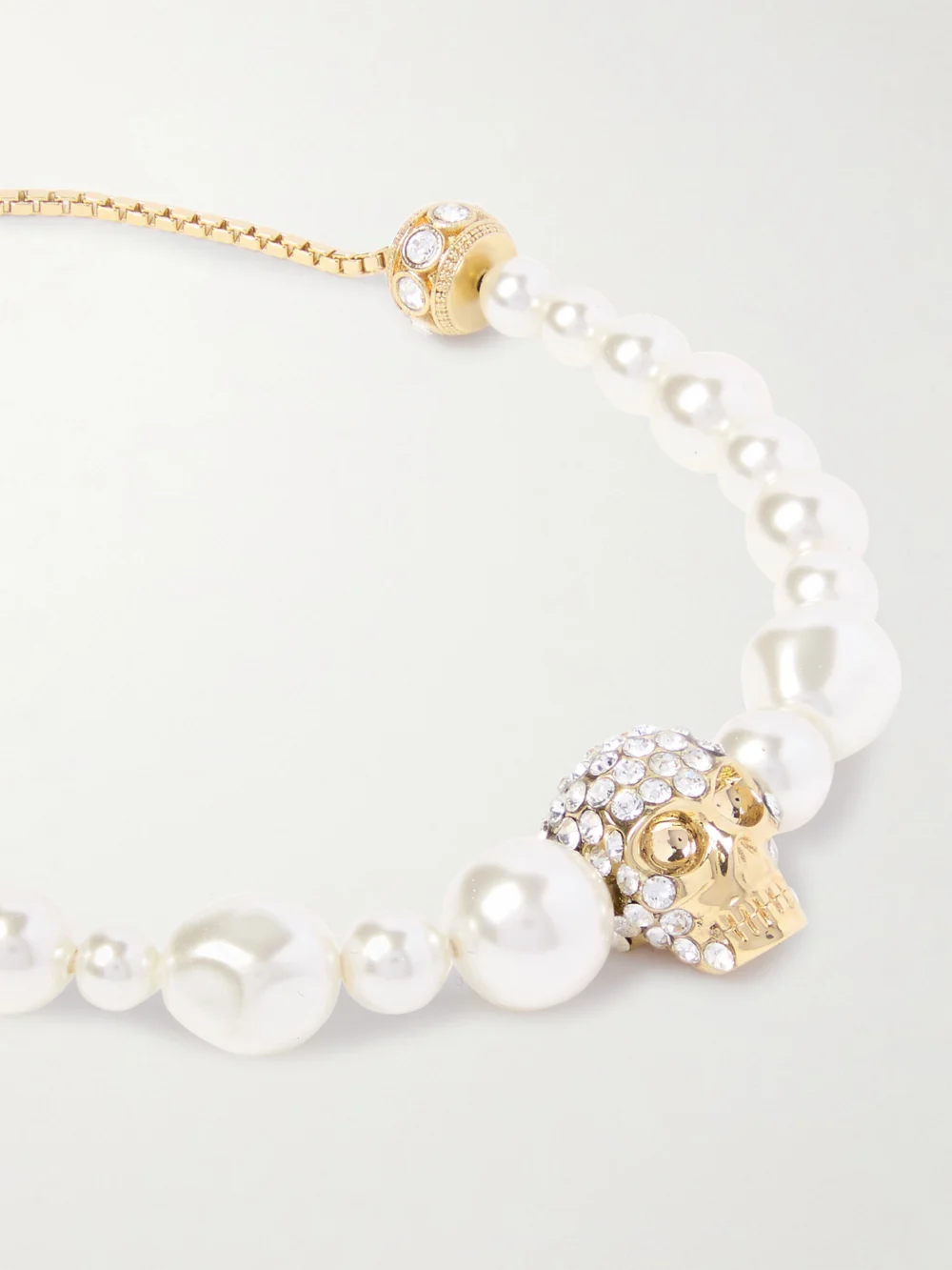 Close-up detail of the Alexander McQueen Gold-tone, Crystal and Pearl-like Bracelet