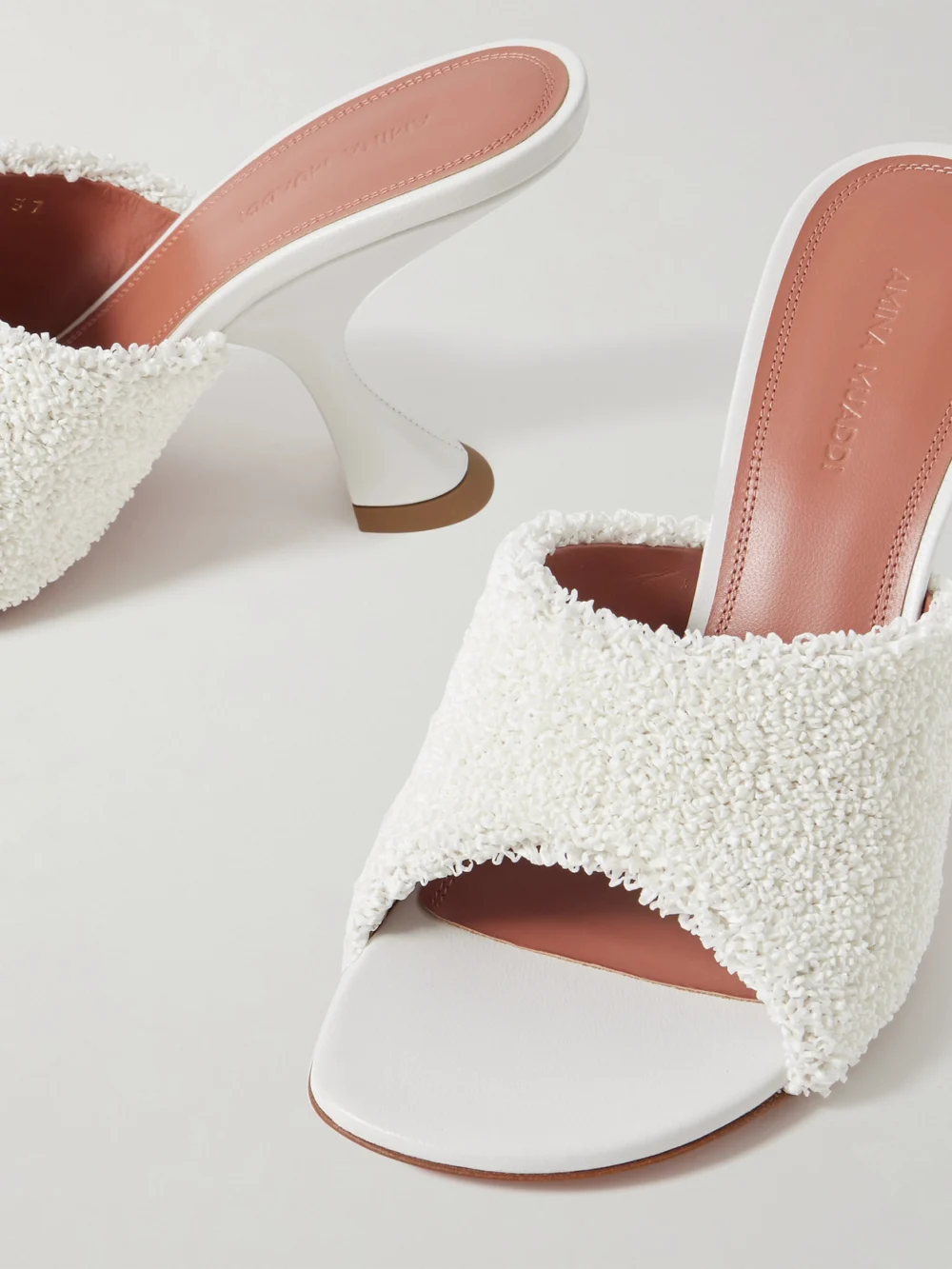 Close-up detail of the Amina Muaddi Taylor Leather-trimmed Raffia Mules