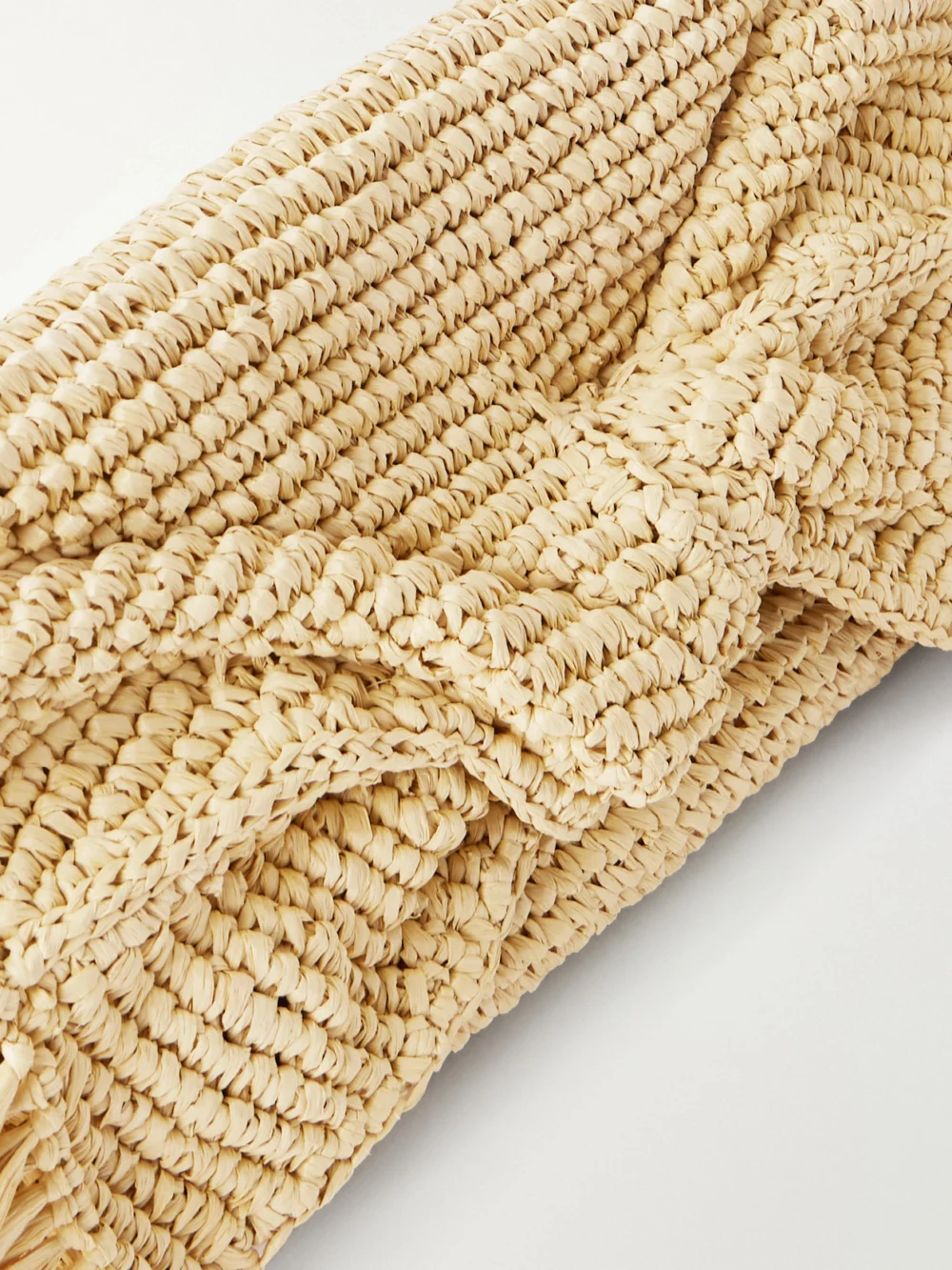 Close-up detail of the Anya Hindmarch Bow Leather-trimmed Raffia Clutch