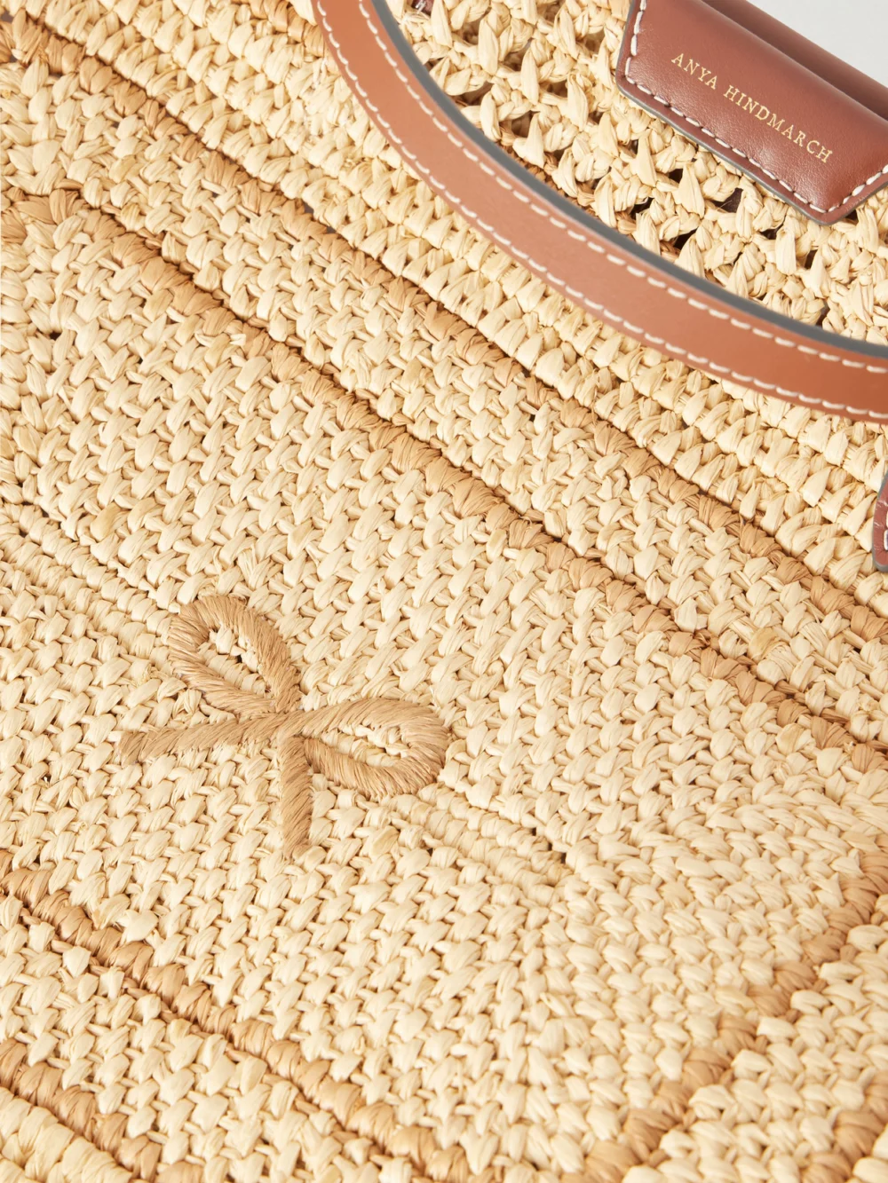 Close-up detail of the Anya Hindmarch Bow Leather-trimmed Raffia Tote