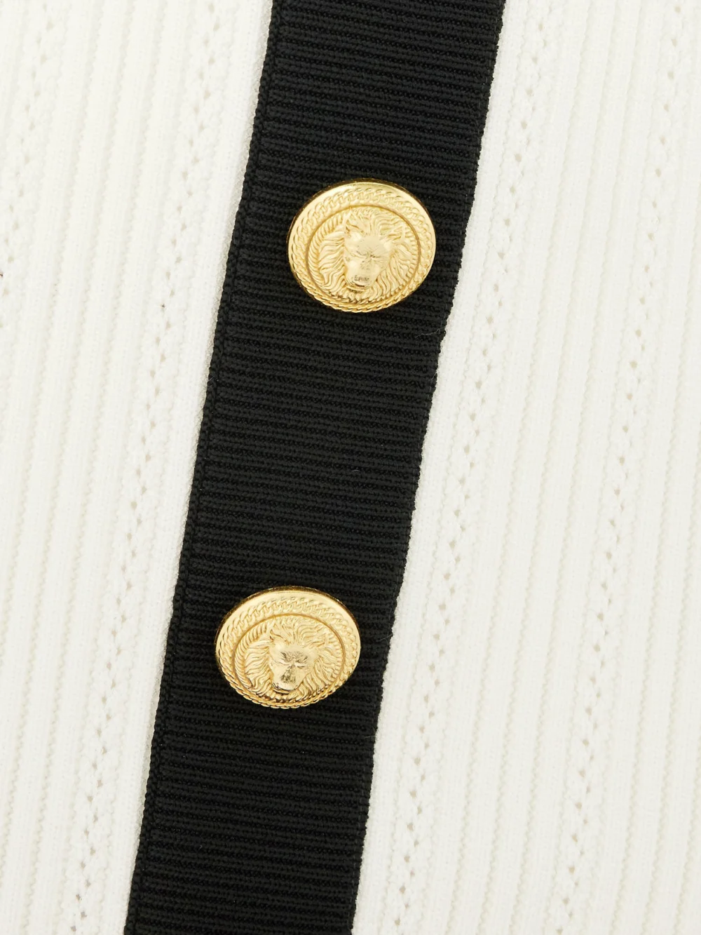 Close-up detail of the Balmain Button-embellished Two-tone Ribbed-knit Mini Skirt