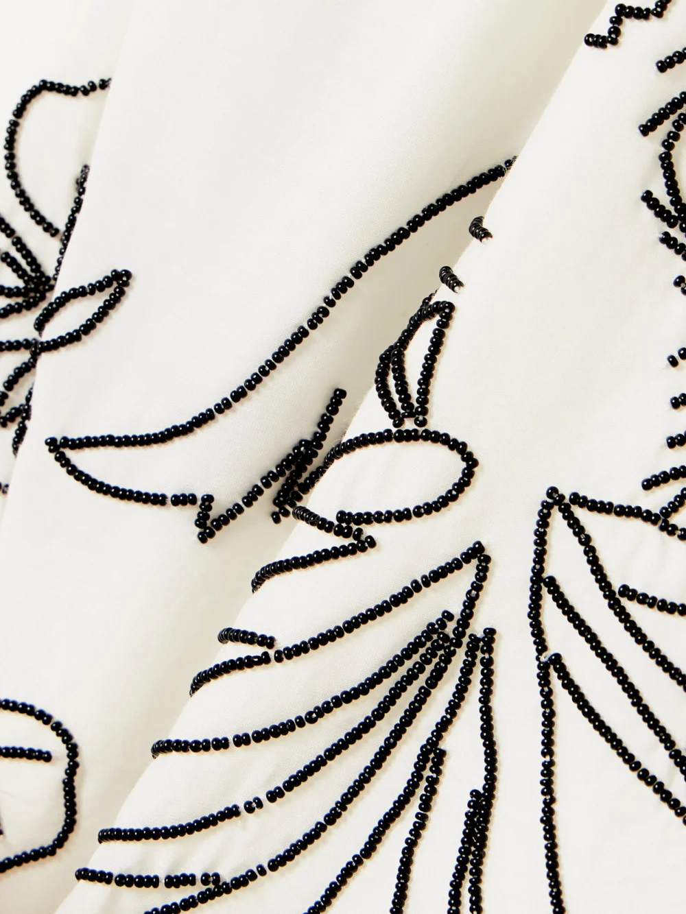 Close-up detail of the Bode Cockatoo Tap Bead-embellished Cotton and Silk-blend Shorts
