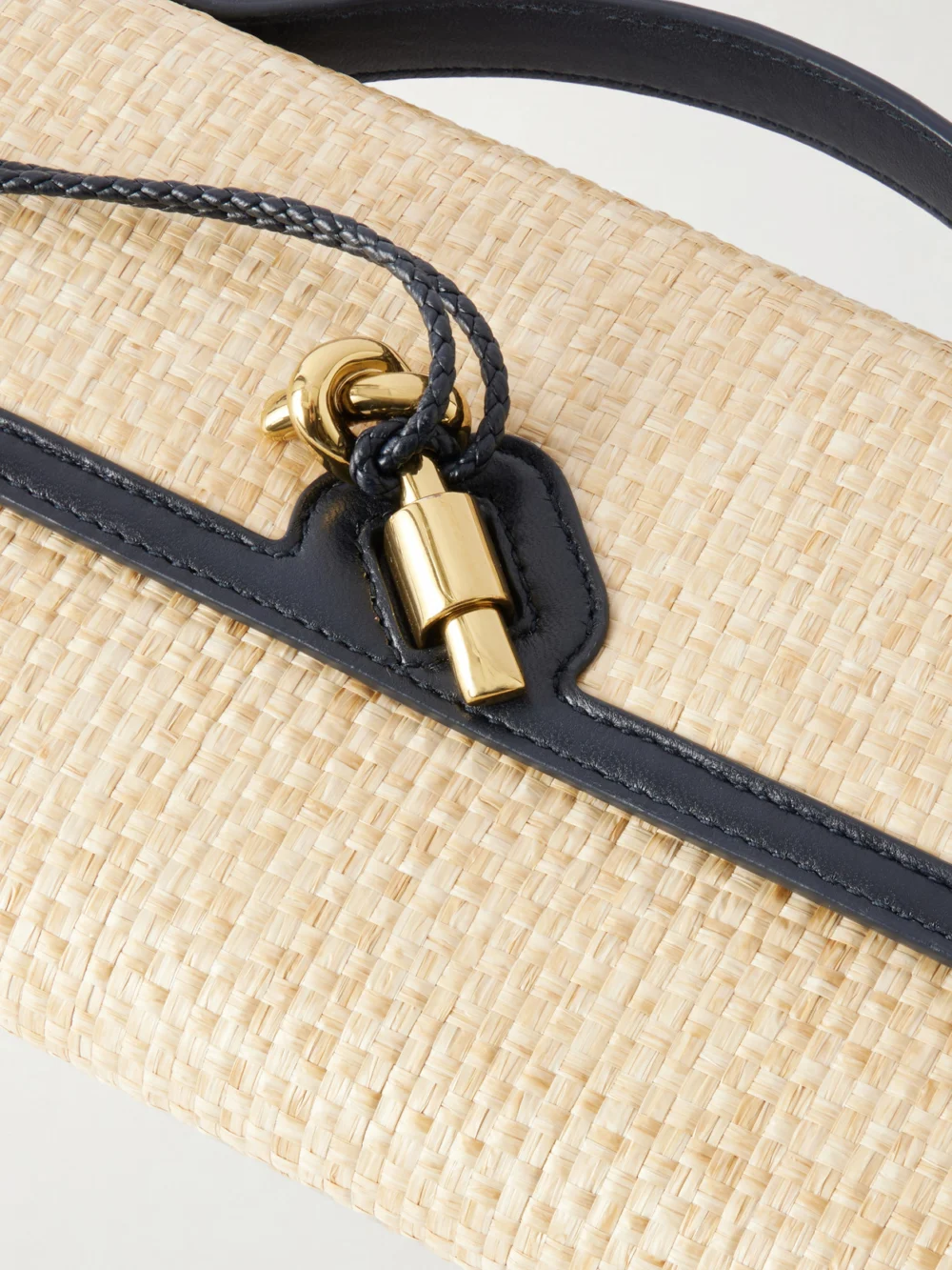 Close-up detail of the Bottega Veneta Andiamo Shaded Leather Trimmed Raffia Clutch