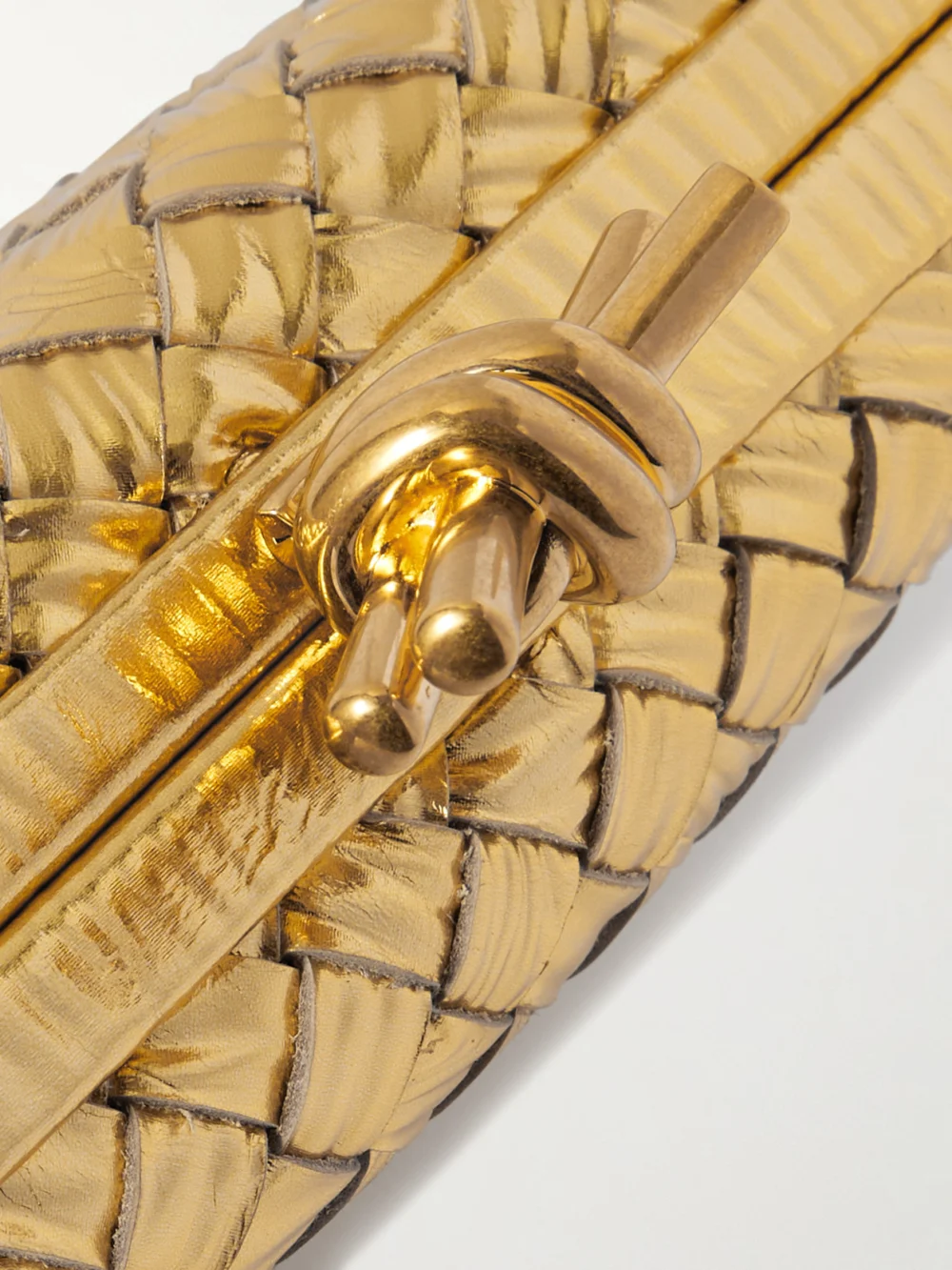 Close-up detail of the Bottega Veneta Knot Padded Intrecciato Metallic Leather Clutch
