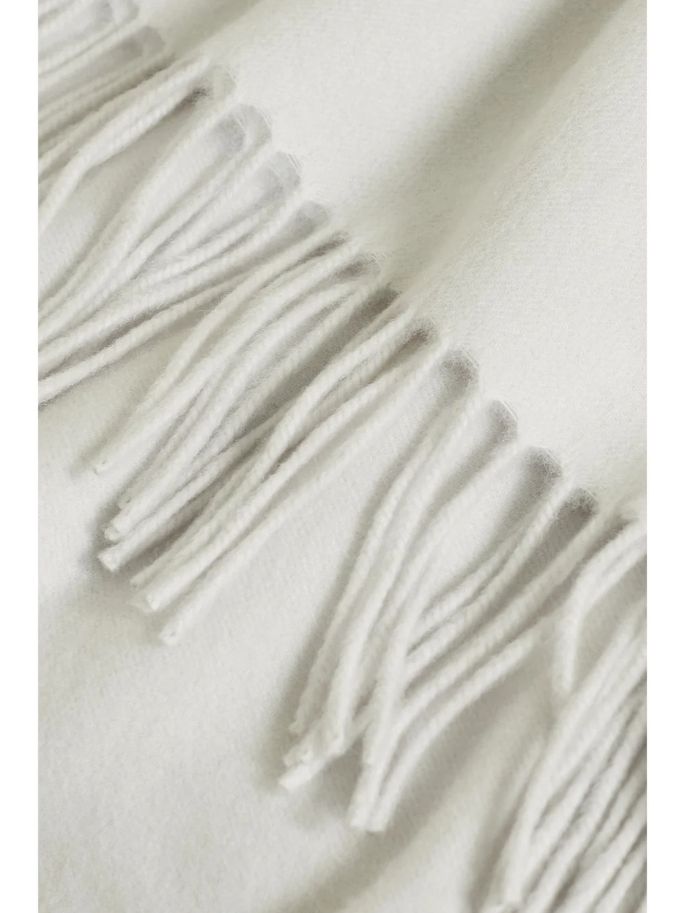 Close-up detail of the Brunello Cucinelli Fringed Cashmere Travel Blanket