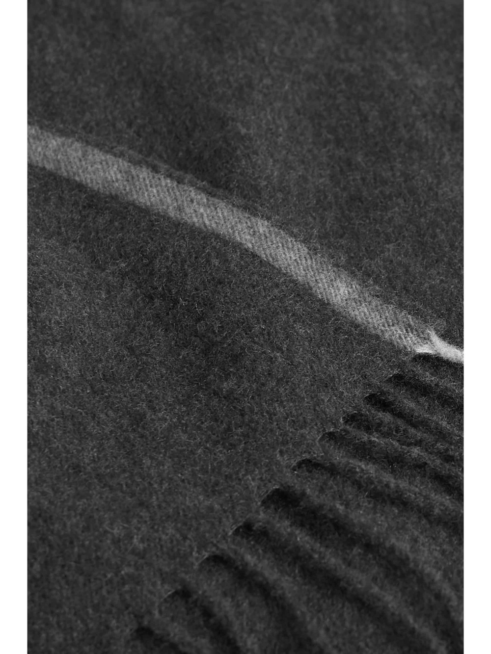 Close-up detail of the Brunello Cucinelli Fringed Two-tone Cashmere Travel Blanket