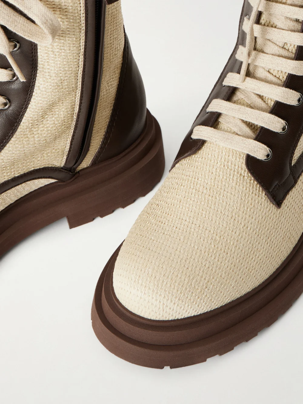 Close-up detail of the Brunello Cucinelli Lace-up Leather-trimmed Raffia Boots