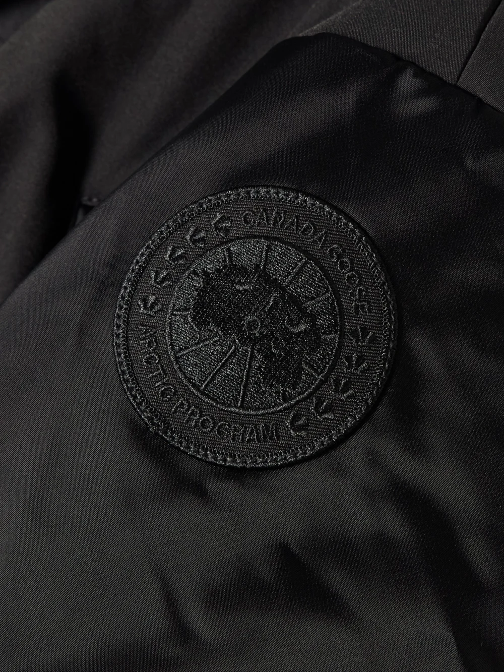Close-up detail of the Canada Goose Claremont Oversized Cropped Layered Satin and Shell Bomber Jacket
