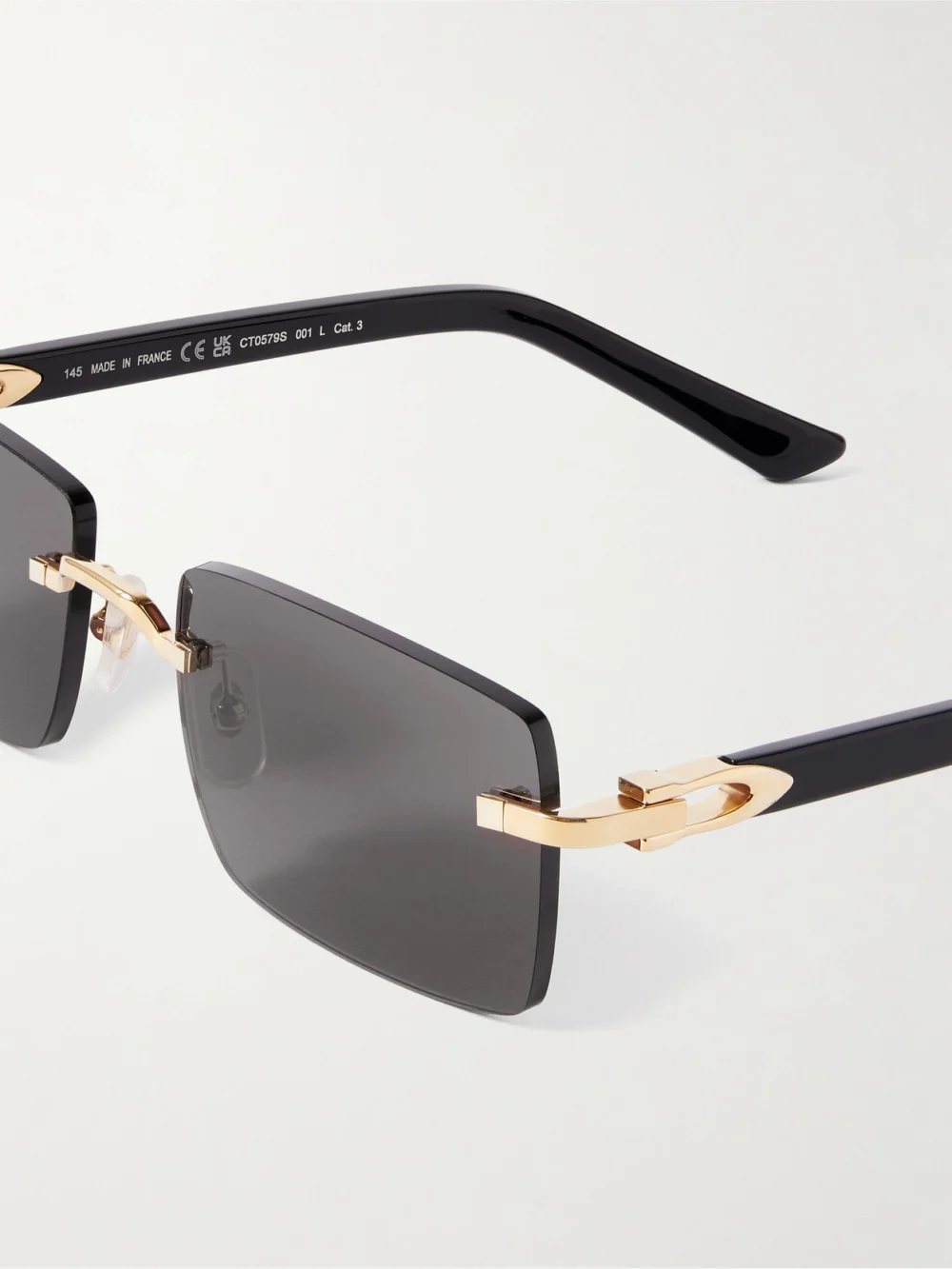Close-up detail of the Cartier Eyewear C Décor Rimless Rectangle-frame Gold-tone and Acetate Sunglasses