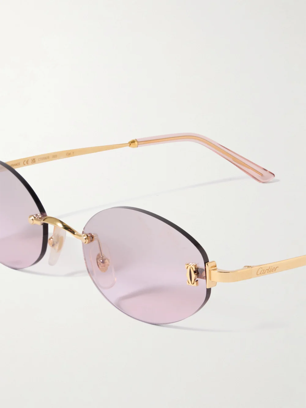 Close-up detail of the Cartier Eyewear Double C Rimless Oval-frame Gold-tone Sunglasses