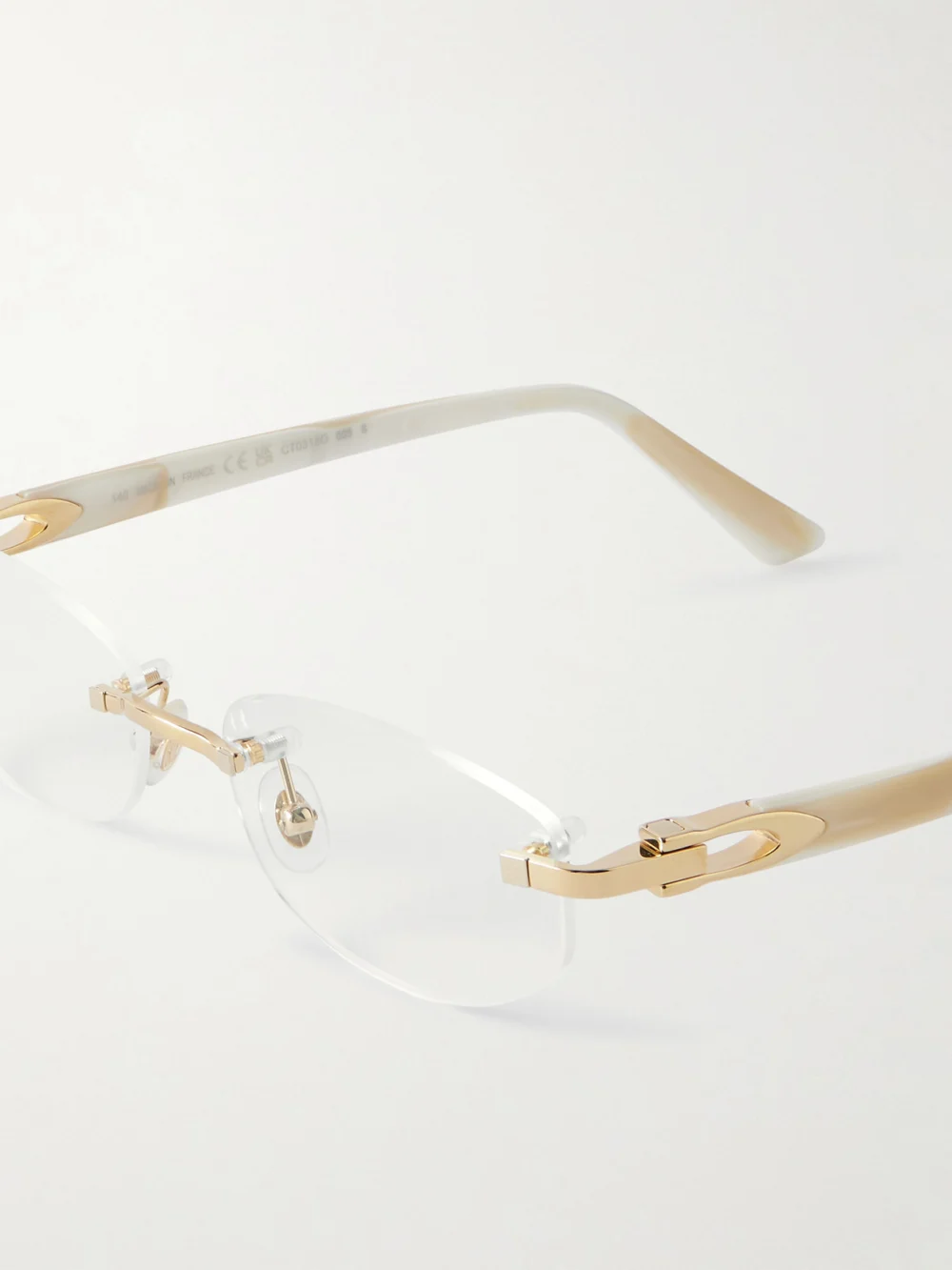 Close-up detail of the Cartier Eyewear Oval-frame Rimless Gold-tone and Acetate Optical Glasses