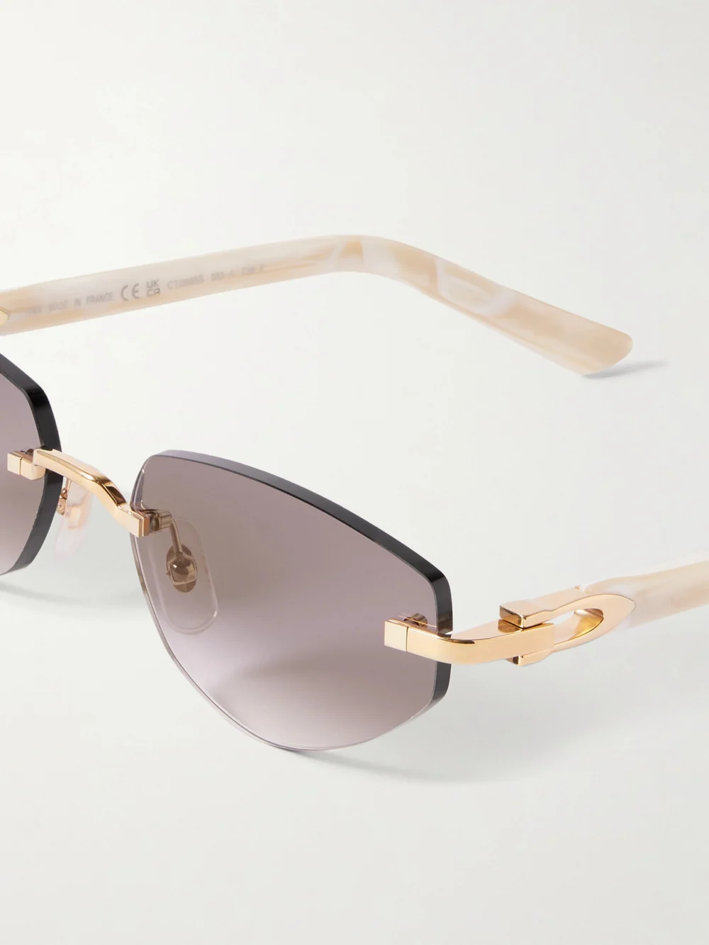 Close-up detail of the Cartier Eyewear Signature C Décor Rimless Cat-eye Gold-tone and Acetate Sunglasses