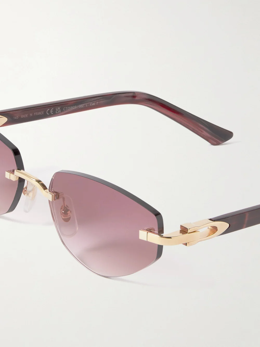Close-up detail of the Cartier Eyewear Signature C Décor Rimless Cat-eye Gold-tone and Acetate Sunglasses