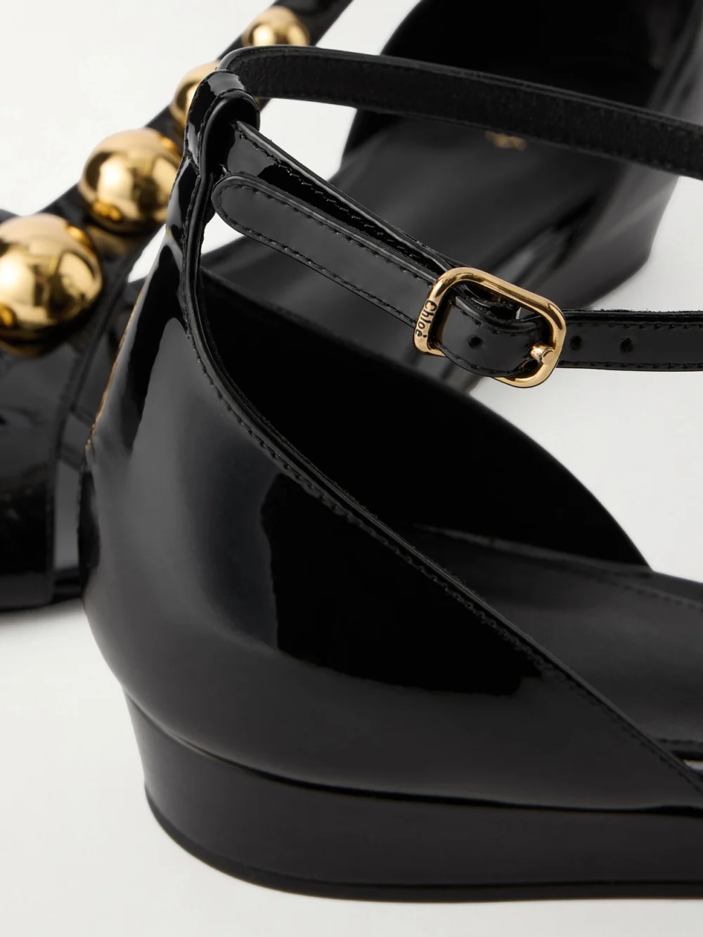 Close-up detail of the Chloé Cleia Studded Patent-leather Wedge Sandals