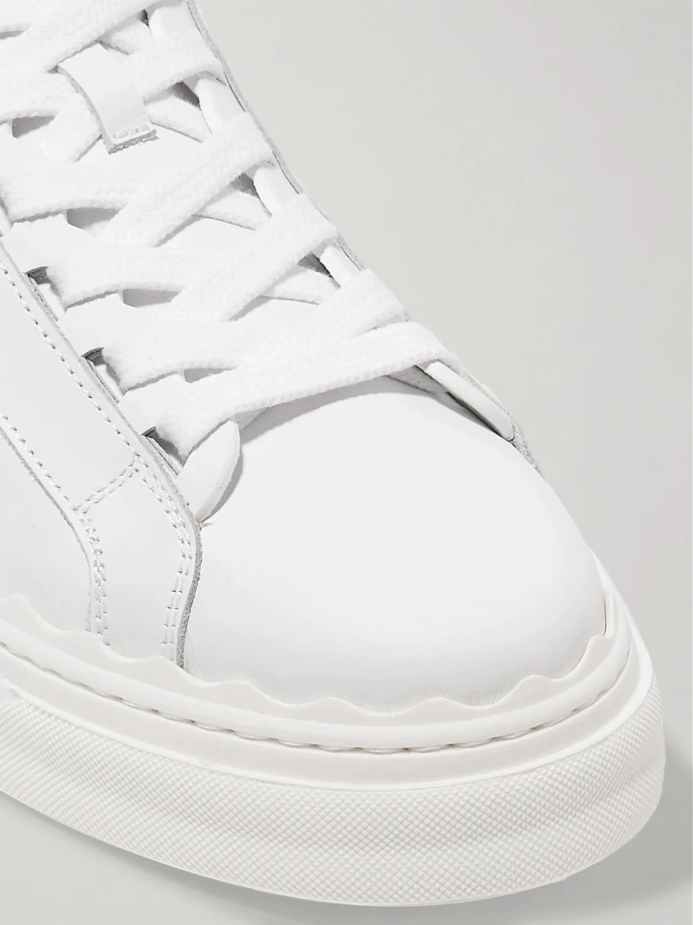 Close-up detail of the Chloé Lauren Scalloped Leather Sneakers