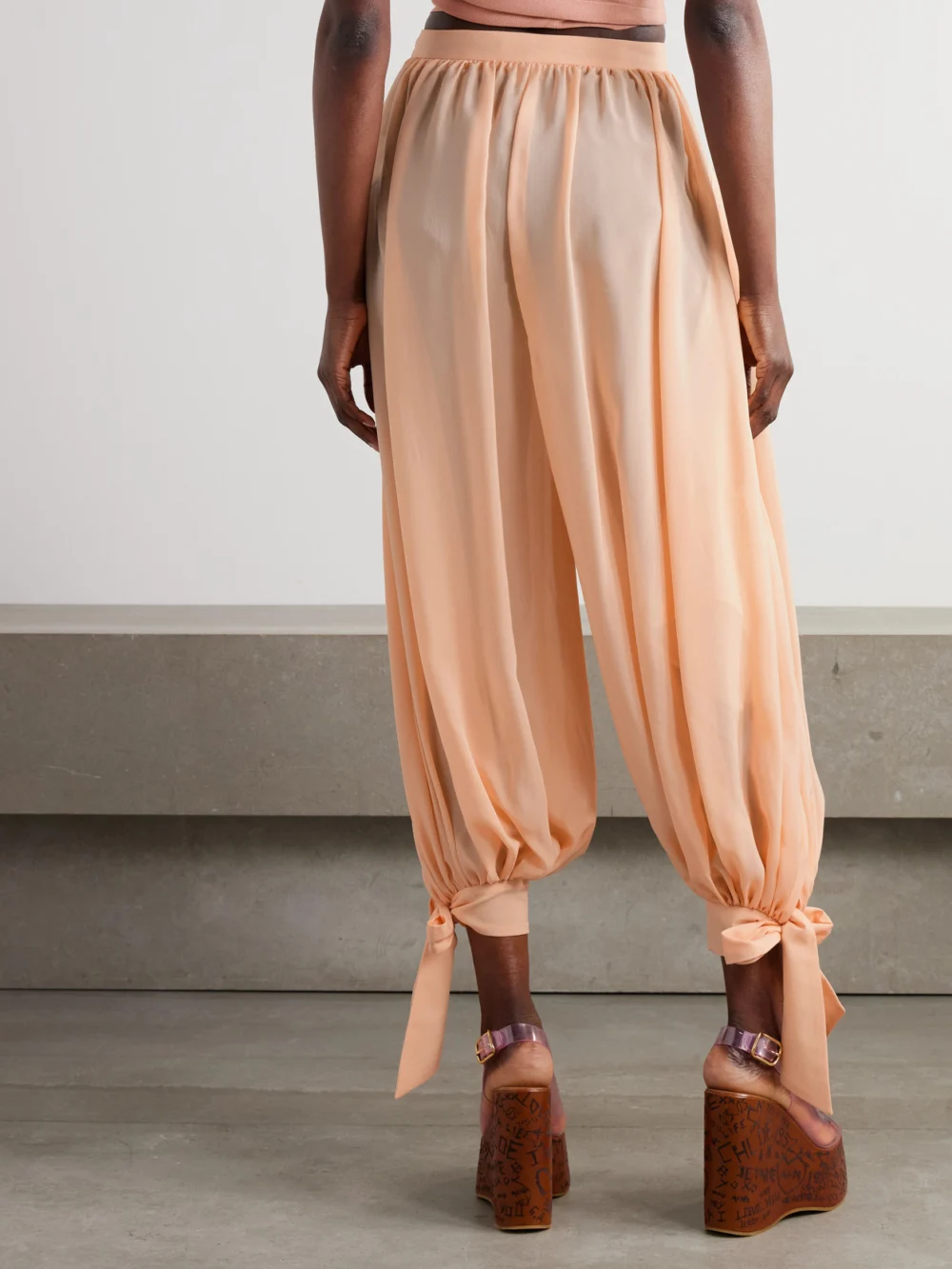 Back view of the Chloé Pleated Silk-charmeuse Tapered Pants