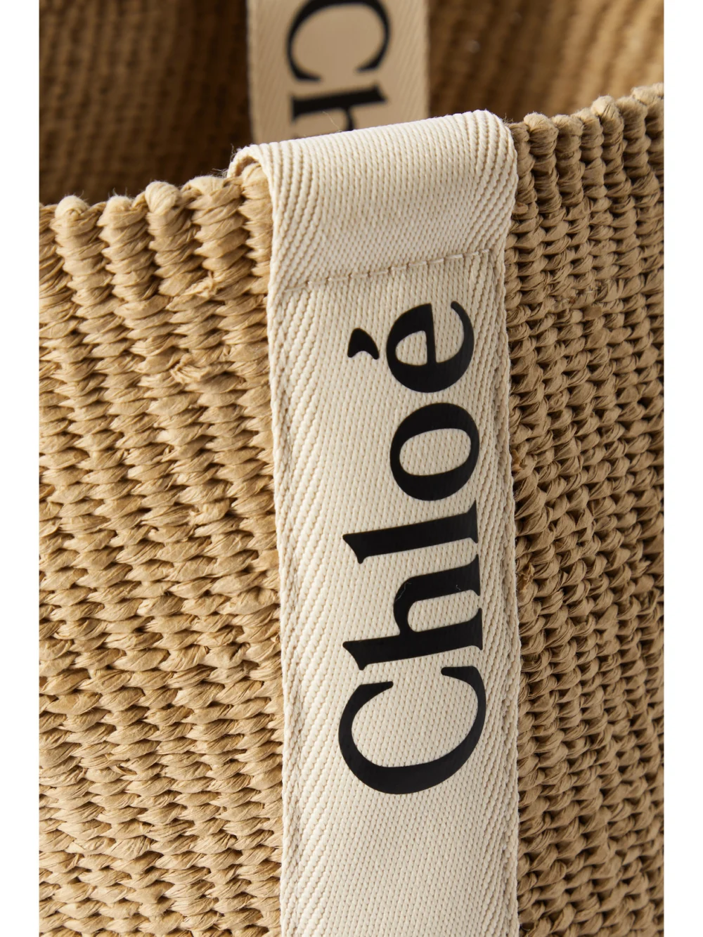 Close-up detail of the Chloé Woody Large Leather-trimmed Raffia Tote