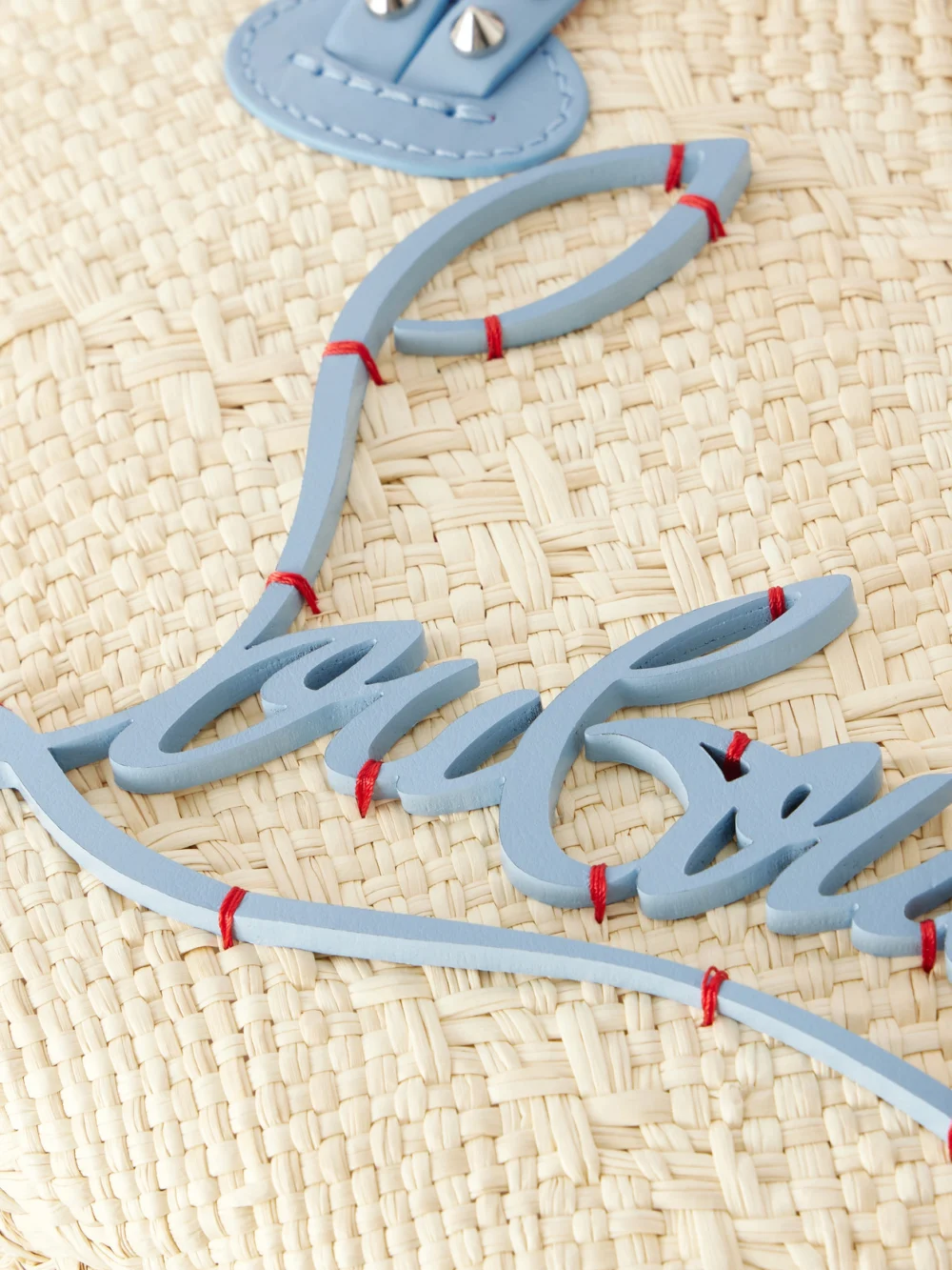 Close-up detail of the Christian Louboutin Cabata Appliquéd Studded Leather-trimmed Raffia Tote