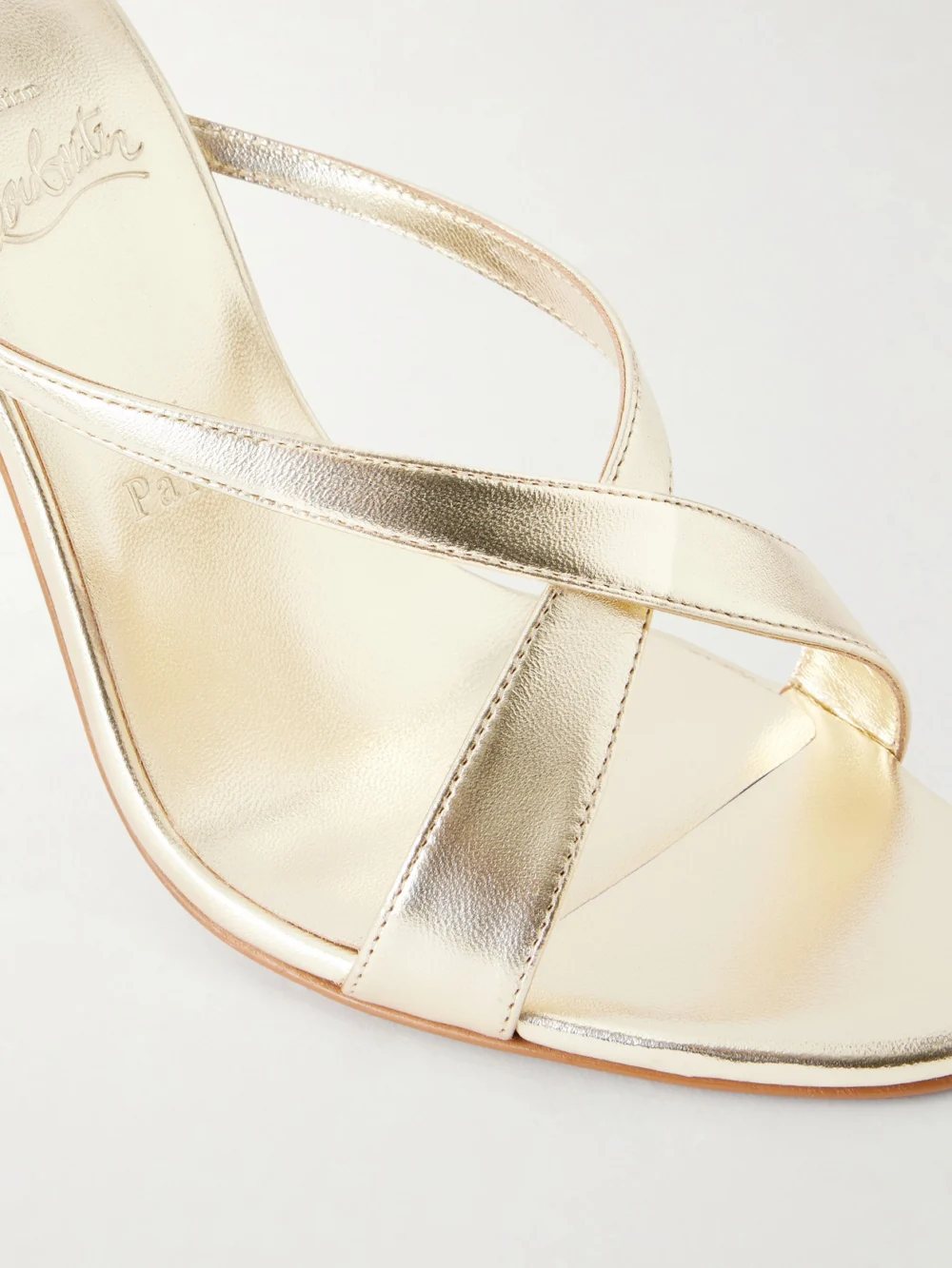 Close-up detail of the Christian Louboutin Mulazee Cross 100 Metallic Leather Mules