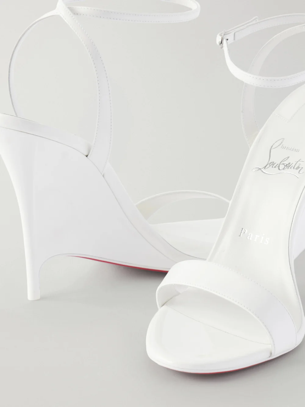 Close-up detail of the Christian Louboutin Zeezeenella 110 Patent-leather Wedge Sandals
